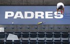  Clint Langford installs new graphics on top of the Padres' dugout in preparation of the Padres home opener and the new baseball season at Petco Park in San Diego on Tuesday. 